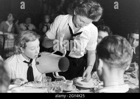 Eiskunstlauf Eine Gruppe der Hitlerjugend dans den Uniformen der HJ und des BDM während des Essen nach dem Formations, Deutschland 1930 er Jahre. Un groupe figureskating des Jeunesses hitlériennes portant des uniformes de la BDM et HJ pendant le dîner après une formation, Allemagne 1930. Banque D'Images