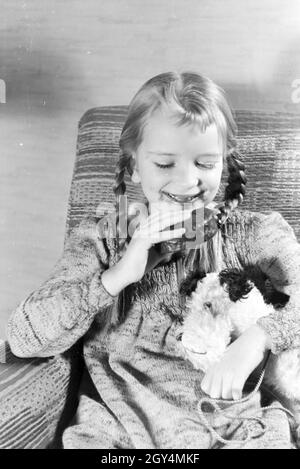 Ein Mädchen isst Liegnitzer Bomben, Deutsches Reich 1930er Jahre. Un girl eating Liegnitzer Bomben, Allemagne 1930. Banque D'Images