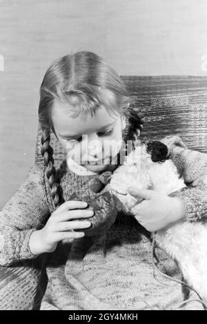 Ein Mädchen isst Liegnitzer Bomben, Deutsches Reich 1930er Jahre. Un girl eating Liegnitzer Bomben, Allemagne 1930. Banque D'Images