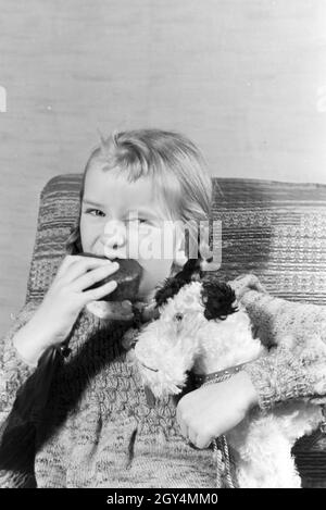 Ein Mädchen isst Liegnitzer Bomben, Deutsches Reich 1930er Jahre. Un girl eating Liegnitzer Bomben, Allemagne 1930. Banque D'Images