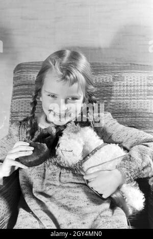 Ein Mädchen isst Liegnitzer Bomben, Deutsches Reich 1930er Jahre. Un girl eating Liegnitzer Bomben, Allemagne 1930. Banque D'Images