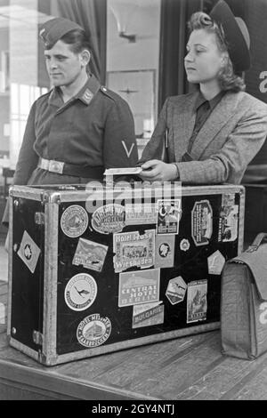 Eine mit einem Passagierin Zollbeamten auf dem Flugplatz Tempelhof à Berlin, Deutschland 1930er Jahre. Une passagère avec un agent des douanes à l'aéroport de Tempelhof de Berlin, Allemagne 1930. Banque D'Images