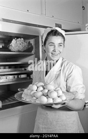 Eine Köchin mit frischen Eiern in der Küche und Gaststätte, Deutschland 1930 er Jahre. Une femme avec des oeufs frais à la cuisine d'un restaurant, l'Allemagne des années 1930. Banque D'Images