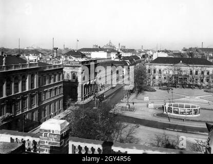 La photo montre Wilhelmstraße et Wilhelmplatz à Berlin-Mitte en 1932.Le ministère des Transports du Reich (à l'extrême gauche), la Chancellerie du Reich avec son extension ainsi que le Palais Borsig (à gauche de la rue, au centre de l'image) et le Prinz-Karl-Palais (aujourd'hui : Ordenspalais, à droite) encadrent la place.Une entrée de métro et la statue du Prince Léopold I d'Anhalt-Dessau sont visibles sur la place.En arrière-plan, on peut voir la colonne de la victoire (à gauche) et le dôme du Reichstag (au centre).[traduction automatique] Banque D'Images