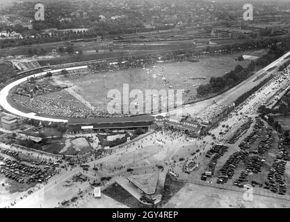 « des foules se sont rassemblées sur le circuit de Berlin pour assister à la course Avus de 1932.Derrière le portail qui dit ''Automobil-Strasse'', les voitures de course se sont alignées et attendent le signal de démarrage.La photo a été prise de la tour de radio de Berlin.En arrière-plan, vous pouvez voir des installations industrielles sur la ligne de chemin de fer Berlin - Grunewald et derrière eux les villas de Grunewald et de Halensee avec le Luna Park.[traduction automatique]' Banque D'Images
