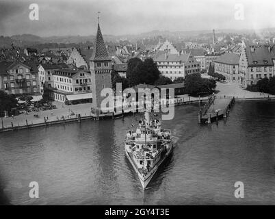 « ce cliché du nouveau phare, qui s'est abattu sur le port de Lindau, a été pris à l'été 1933 lors du tournage du film UFA du réalisateur Karl Hartl « son Altesse Sérénissime, la Salescalovante », sorti en novembre 1933.Un cuiseur vapeur à aubes prend juste de la vitesse après avoir coulé de la jetée.Sur la promenade du lac, les marcheurs passent l'hôtel Reutemann, l'hôtel Helvetia, le mangturm et l'hôtel Lingauer Hof (de gauche à droite).[traduction automatique]' Banque D'Images