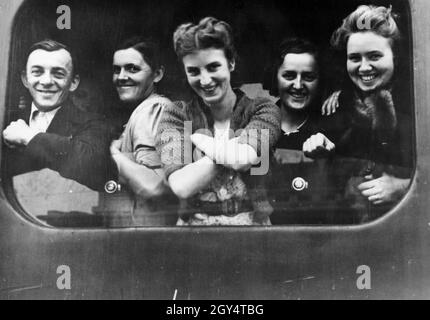 Une fois évacués par le gouvernement français, les alsaciens et les résidents de Lorraine sont maintenant transportés vers la région annexée par les Allemands.Sur la photo : quatre femmes et un homme regardent par la fenêtre d'un train, riant.[traduction automatique] Banque D'Images