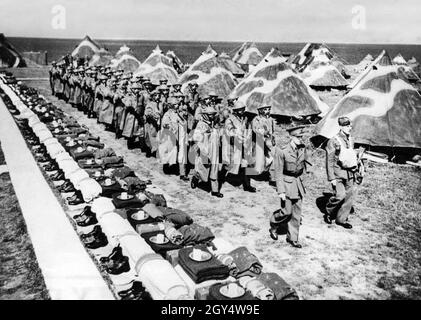 Les troupes britanniques se préparent en Grande-Bretagne à une possible invasion allemande de l'Angleterre dans le cadre de l'opération Sea Lion : une équipe de soldats Royal Marines marche à travers un camp sur la côte ouest de l'Angleterre portant des masques respiratoires.[traduction automatique] Banque D'Images