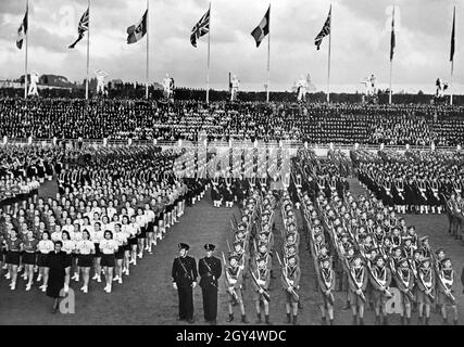 'Les garçons et les filles de l'organisation fasciste de jeunesse ''Gioventù italiana del littorio'' (GIL) chantent dans le Stade de marbre de Rome le 12 janvier 1939.L'occasion a été la visite du gouvernement britannique en la personne du premier ministre Neville Chamberlain et du ministre des Affaires étrangères Lord Halifax.Avec Mussolini et d'autres personnes de haut rang du régime fasciste, ils ont visité le stade.En plus de la réception de la chanson, les jeunes ont démontré leurs compétences sportives dans les exercices de gymnastique.[traduction automatique]' Banque D'Images