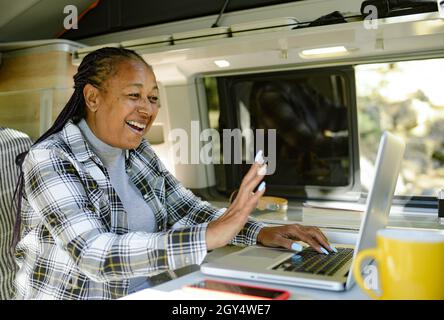 Bonne femme noire en train de discuter vidéo en camping-car Banque D'Images