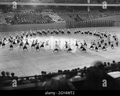 'Le dimanche 13 juin 1937, 1200 membres de l'Opéra Nazionale Balilla sont arrivés à la gare Anhalter Bahnhof de Berlin.Parmi eux se trouvait également une section de filles de la ''Giovani Italiane''.La photo montre les filles italiennes le 16 juin dans le Deutschlandhalle à Berlin-Westend exécutant les chorégraphies répétées, ici exercices avec le longbow.Parmi d'autres, les jeunes italiens et les membres des organisations socialistes nationales sont assis dans les tribunes.[traduction automatique]' Banque D'Images