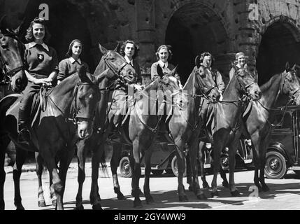 Un groupe de jeunes femmes à cheval se tient devant le Colisée de Rome en 1939.Les femmes appartiennent à l'organisation fasciste de jeunesse Gioventu Italiana del Littorio.[traduction automatique] Banque D'Images