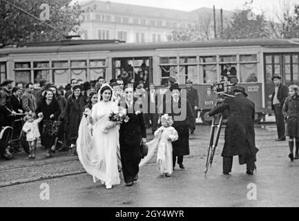 Le 10 novembre 1941, un mariage a eu lieu à Milan où la mariée, la fête de mariage et le prêtre sont arrivés à l'église par tram.En raison des restrictions imposées par la guerre, c'était la seule façon d'arriver à l'église où le mariage a eu lieu.La mariée, accompagnée de son père, est à la tête de la voie.Une fille tient le train.Sur la droite, un caméraman filme la scène.[traduction automatique] Banque D'Images