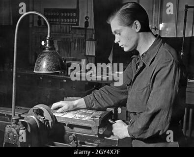 Un apprenti stéréotype à une machine à bordures.[traduction automatique] Banque D'Images