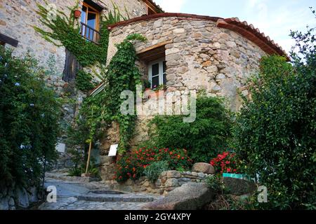 Maison extérieure ornée de plantes grimpantes et de fleurs en fleur dans la ville d'EUS, département des Pyrénées-Orientales, France Banque D'Images