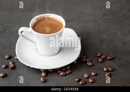 Café turc sur fumée et grains de café sur table en pierre sombre Banque D'Images