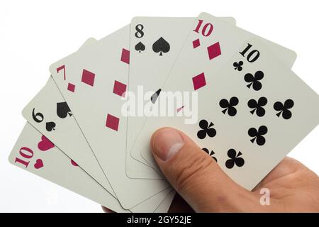 La main d'un homme tient un fan de six cartes à jouer de couleurs et de costumes différents.Photographié sur un arrière-plan blanc et propre avec un écrêtage Banque D'Images