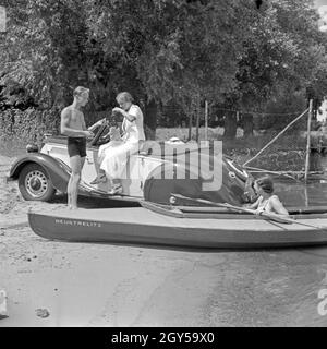 Für den Werbefoto Personenkraftwagen Ford mit einer jungen Frau Eifel und einem Paar mit Paddelboot Deutschland 1935. Photo commerciale pour le passager car Ford Eifel avec couple et de canoë et des pagayeurs, Allemagne 1935. Banque D'Images