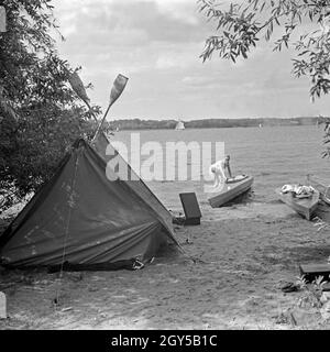 Werbefoto für das Zelt und Klepper Faltboot : eine junge Frau holt ein Boot am Strand von voit une terre, Deutschland 1930 er Jahre. Un foldboat publicité für Klepper et tente : une jeune femme de prendre le bateau sur la rive d'un lac, l'Allemagne des années 1930. Banque D'Images