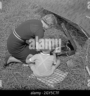 Eine junge Frau und ein kleiner Junge hören beim zelten Musik von einem Electrola Koffer 106 Grammophon, Deutschland 1930er Jahre. Une femme et un petit garçon écoute de musique joué par un gramophone Electrola Koffer 106, tandis que le camping, Allemagne 1930. Banque D'Images