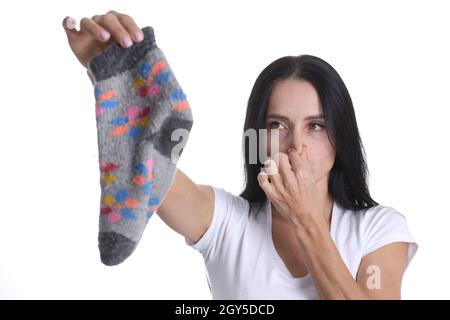 Portrait d'une jeune femme couvrant le nez et tenant la chaussette à la main Banque D'Images