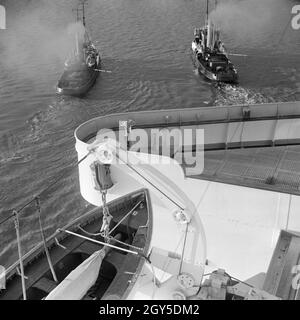 Schlepper aus das deutsche Passagierschiff 'Europa' dans die Werft à Bremerhaven, Allemagne Allemagne Années 1930 er Jahre. Remorqueurs tirant le navire à passagers allemand 'Europa' à l'arsenal à Bremerhaven, Allemagne 1930. Banque D'Images