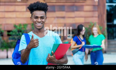 Un étudiant afro-américain réussi montre le pouce avec un groupe d'étudiants internationaux à l'extérieur de la ville Banque D'Images