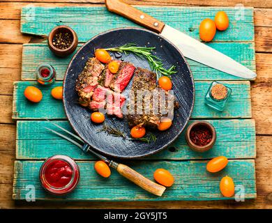 Steak de bœuf fraîchement coupé en tranches rôti au kumquat, au romarin et aux épices. Entrecote de veau sur une plaque Banque D'Images