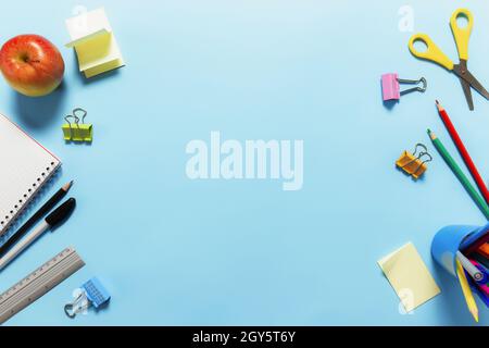 Plat avec école, travail ou concept éducatif avec divers accessoires d'école, stylos, crayon, bloc-notes, trombones, pomme, règle, ciseaux, pape Banque D'Images