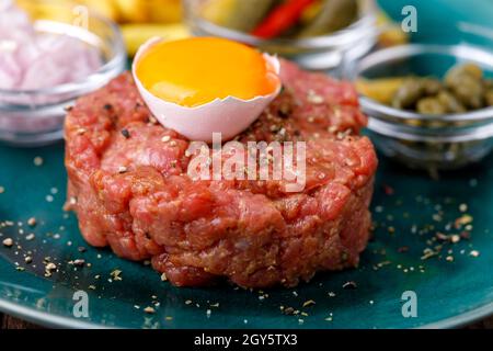 steak tartare avec œuf ouvert sur bois Banque D'Images