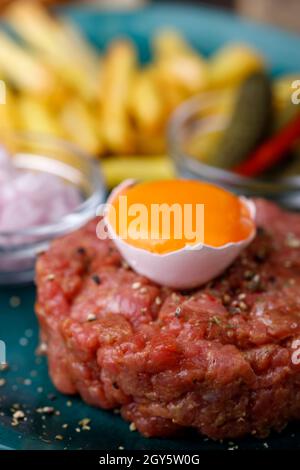 steak tartare avec œuf ouvert sur bois Banque D'Images