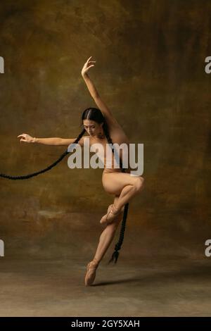 Portrait de danse ballerine tendre et passionnée isolée sur fond sombre de vigne.Performances de style artistique Banque D'Images