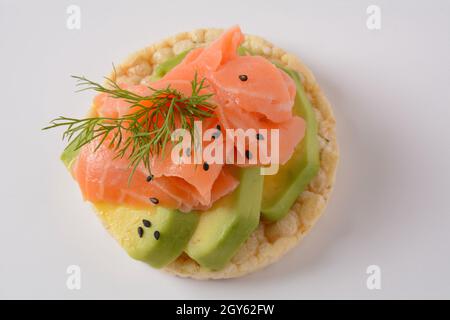 Pain de riz croustillant, avocat, tranches de saumon et aneth frais Banque D'Images