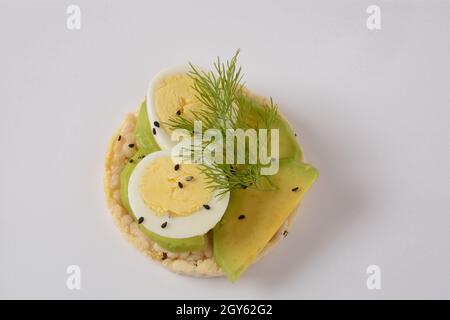 Pain de riz croustillant, avocat, tranches d'œufs durs et aneth frais Banque D'Images