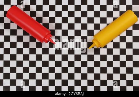 Bouteilles de ketchup et de moutarde sur une table à carreaux Banque D'Images