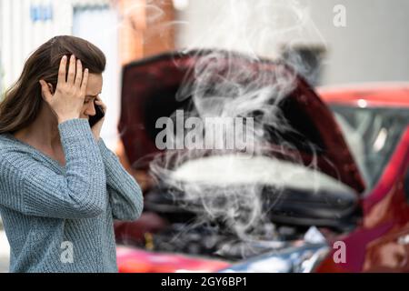 Femme en train de parler à un mécanicien de voitures fiable. Panne et collision Banque D'Images