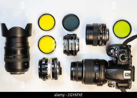 appareil photo, ensemble d'objectifs photo et filtres optiques couleur sur fond blanc.Flat lay, vue de dessus. Banque D'Images