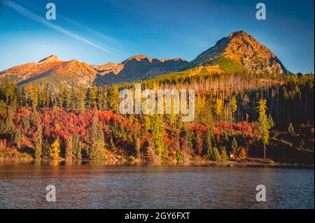 Lac Strbske pleso avec les sommets de Predne Solisko, Mlynicke Solisko et Strbske Solisko en automne Vysoke Tatry en Slovaquie Banque D'Images