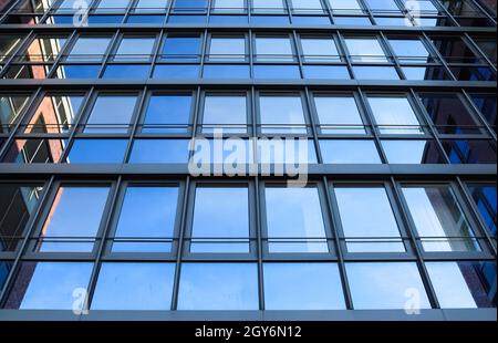 Bureau moderne en verre avec des façades de bâtiment et reflétant la lumière du soleil dans les fenêtres trouvés à Kiel en Allemagne Banque D'Images