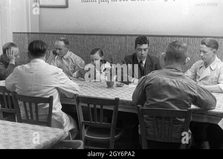 Angestellte des Musterbetriebs Wilhelm Plum nach Feierabend, Deutsches Reich 1941. Employés de la plante modèle Wilhelm Plum après la fermeture, Allemagne 1941. Banque D'Images