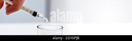 un chercheur vide le liquide d'un flacon dans un contenant en verre pour trouver un vaccin contre le virus dans un laboratoire d'analyse et de recherche scientifique. Science a Banque D'Images