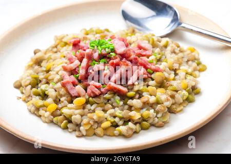 porridge de légumineuses avec bacon frit et ciboulette Banque D'Images