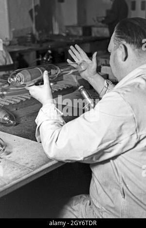 Ein Mitarbeiter einer Leuchtröhrenfabrik bei der Planung von Leuchtöhre, 1930er Jahre Deutschland. Un membre du personnel la production d'un tube fluorescent, Allemagne 1930. Banque D'Images