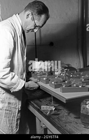 Ein Mitarbeiter einer Leuchtröhrenfabrik bei der Planung von Leuchtöhre, 1930er Jahre Deutschland. Un membre du personnel la production d'un tube fluorescent, Allemagne 1930. Banque D'Images