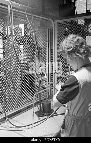 Eine/bei der Produktion von Leuchtröhren, Deutschland 1930 er Jahre. Une femme memmber produisant des tubes fluorescents, Allemagne 1930. Banque D'Images