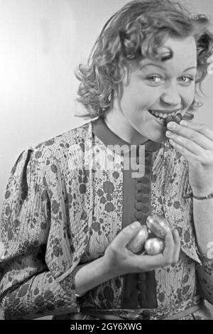 Porträt eines jungen Mädchens, Schokoladenostereier essend, 1930er Jahre Deutschland. Portrait d'une jeune fille de manger des oeufs de pâques en chocolat, Allemagne 1930. Banque D'Images