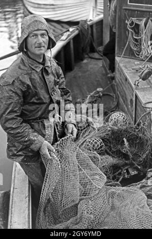 Ein Fischer bereitet die Netze zum vor der Fischfang dans Ostsee, Deutschland 1930 er Jahre. Un pêcheur préparer les filets pour la pêche en mer Baltique, Allemagne 1930. Banque D'Images