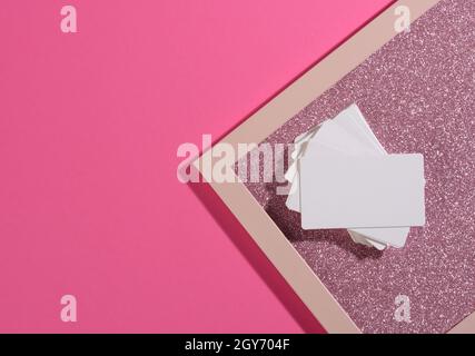 la carte de visite rectangulaire vierge se trouve sur un fond rose moderne de feuilles de papier avec une ombre. Modèle commercial, pose à plat Banque D'Images