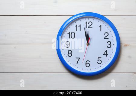 Horloge murale bleue avec minuit nouvel an sur fond en bois Banque D'Images