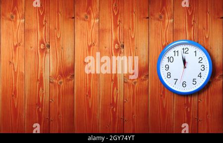 Horloge murale bleue avec minuit nouvel an sur fond en bois Banque D'Images